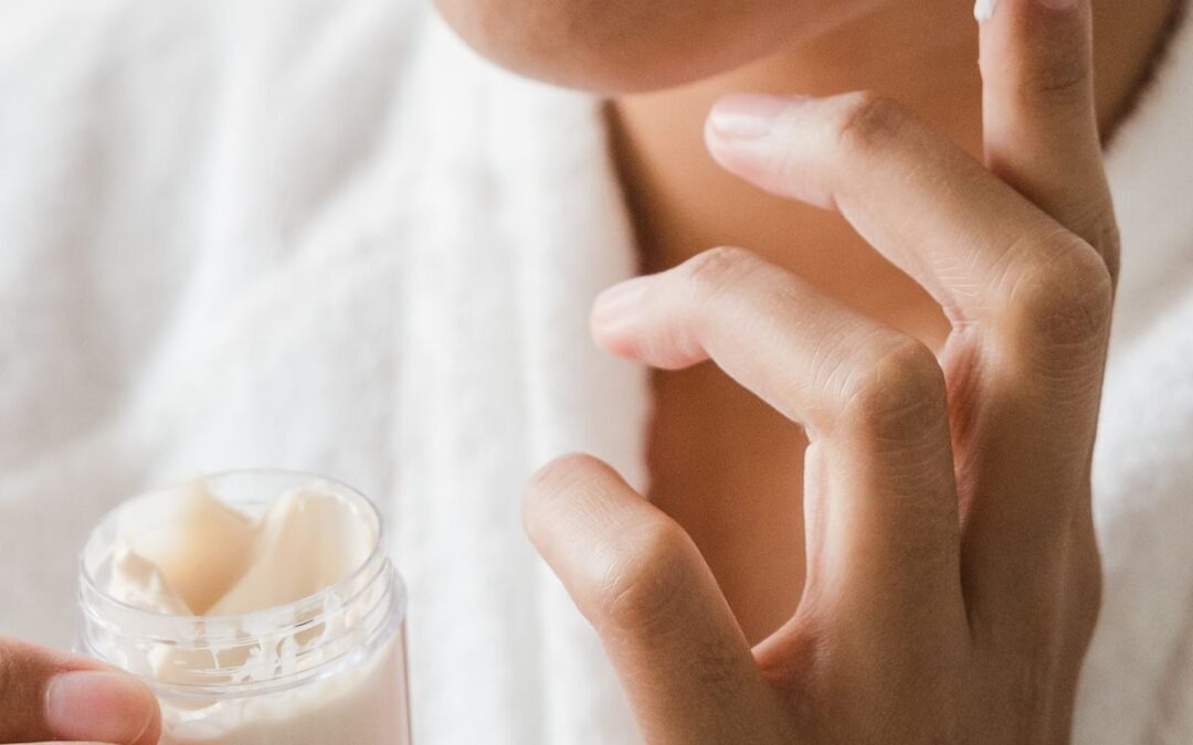 Person applying facial skincare cream