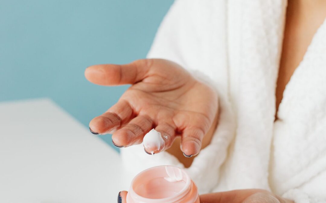 Person applying facial skincare cream