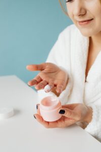Person applying facial skincare cream