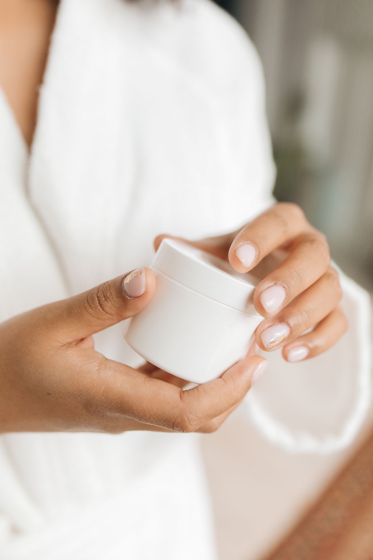 Person holding a facial cream jar