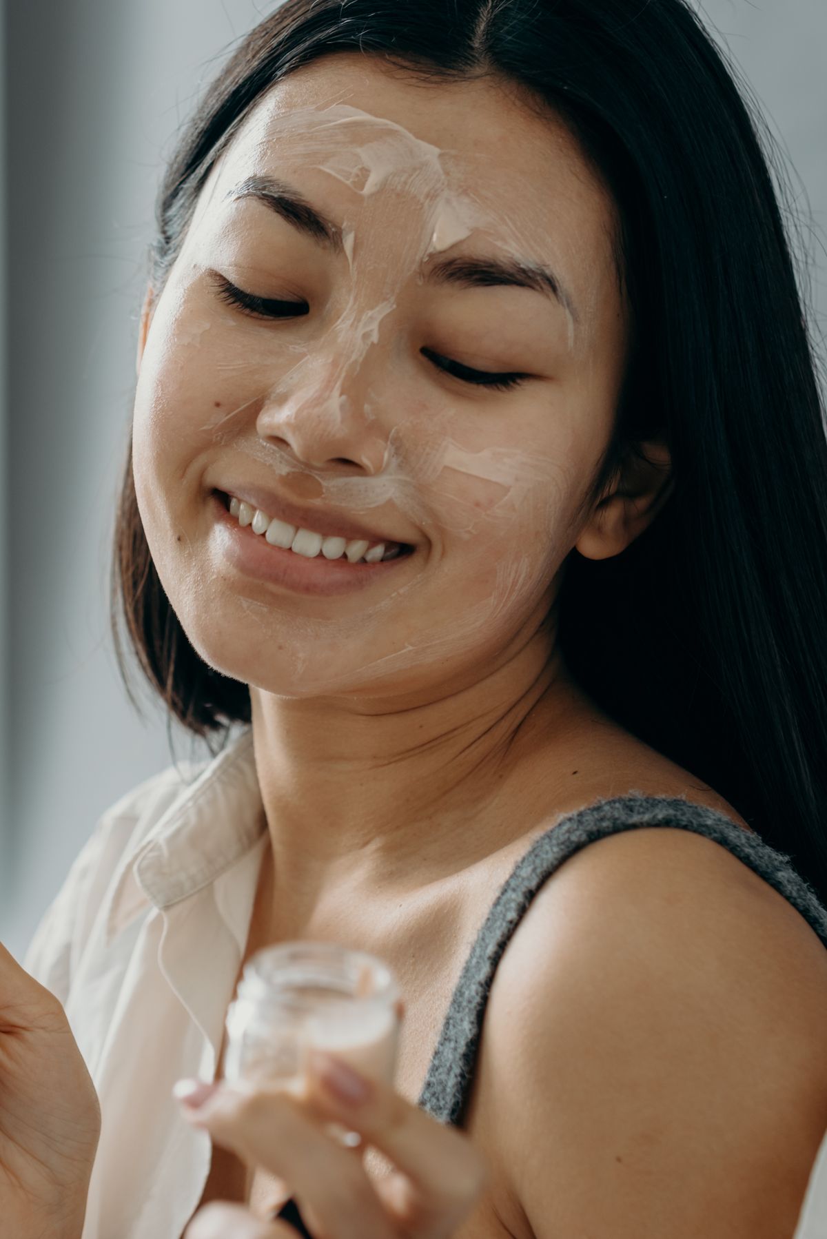 Person applying facial skincare cream