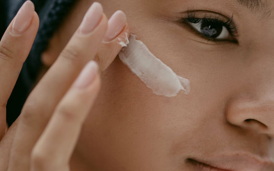 Person applying facial skincare cream