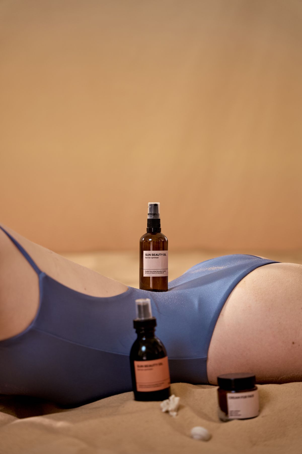Sun-care bottle held beside an arm