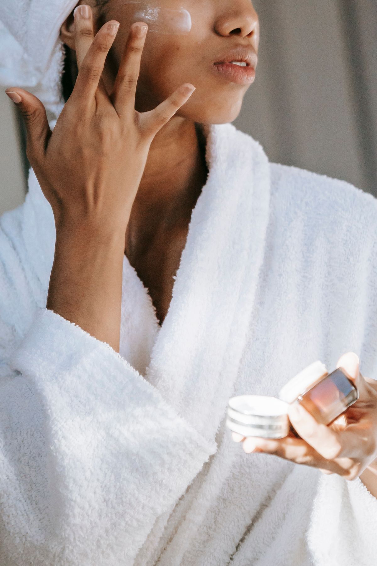Person applying facial skincare cream