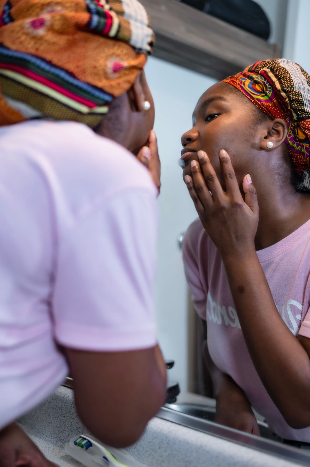 Person looking closely at their face in a mirror